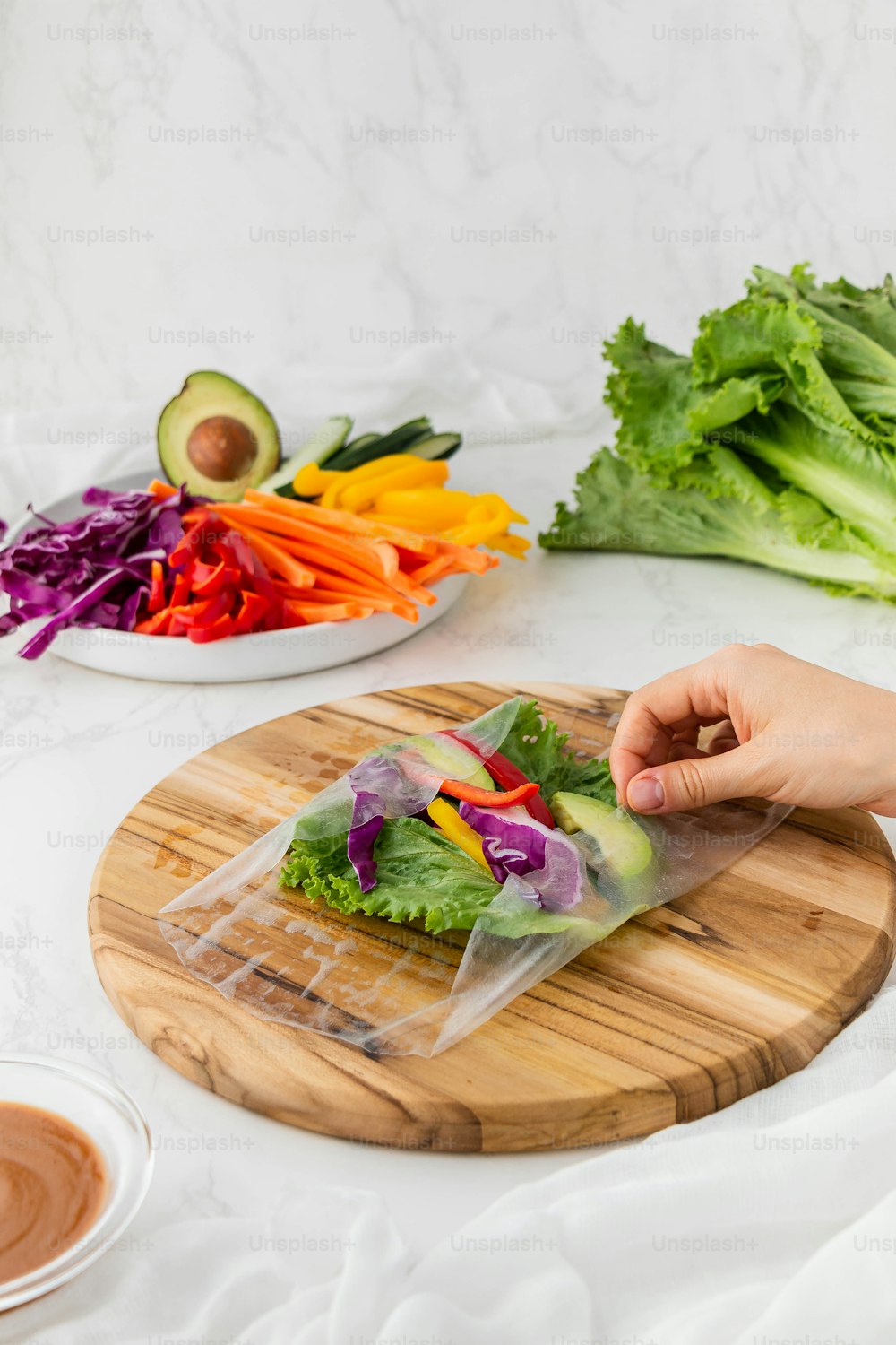 a person cutting up a salad on a cutting board