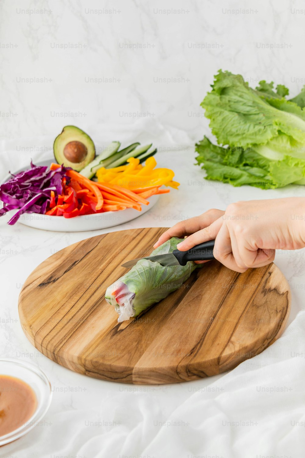 uma pessoa cortando um vegetal em uma tábua de corte