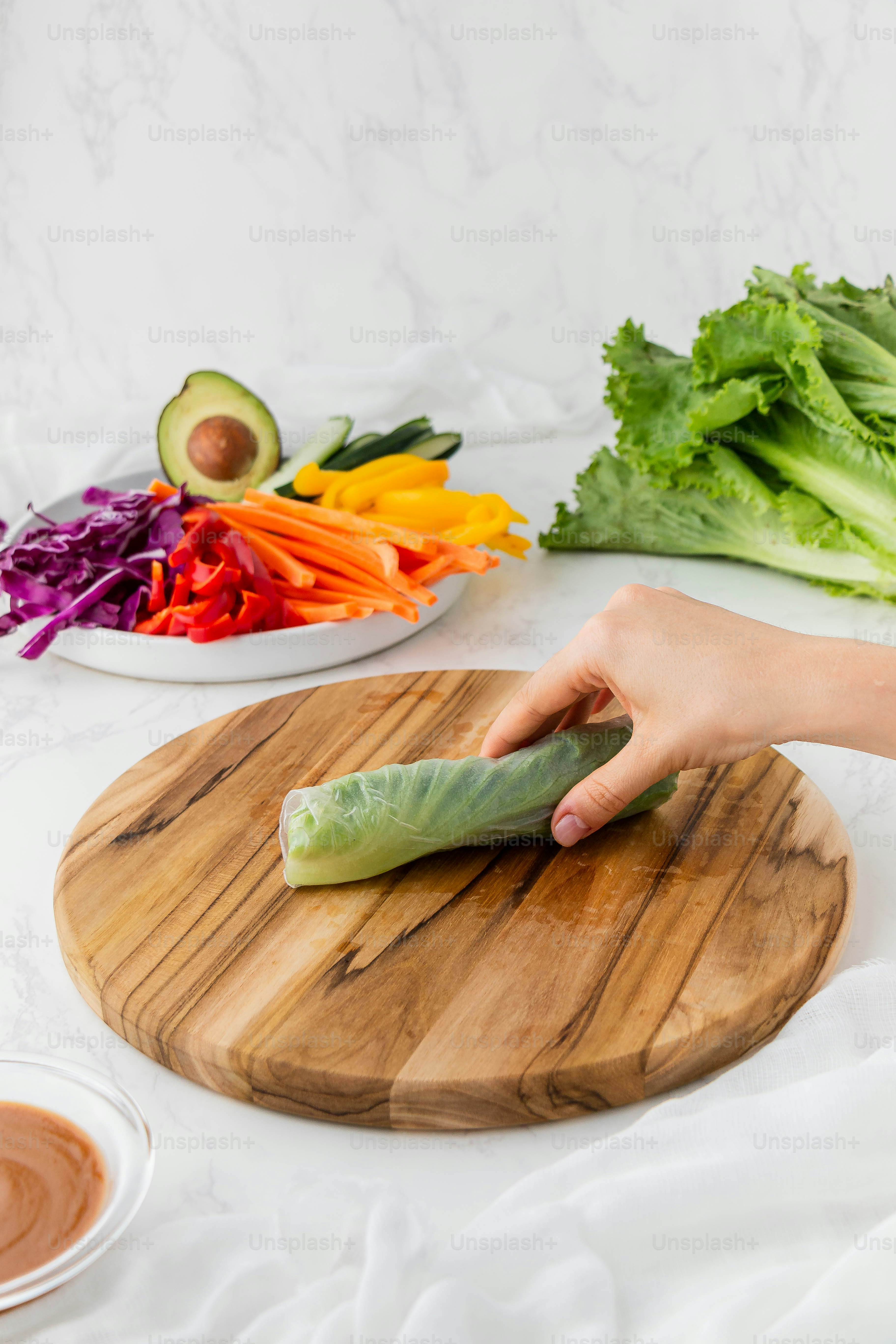 a person is cutting a vegetable on a cutting board