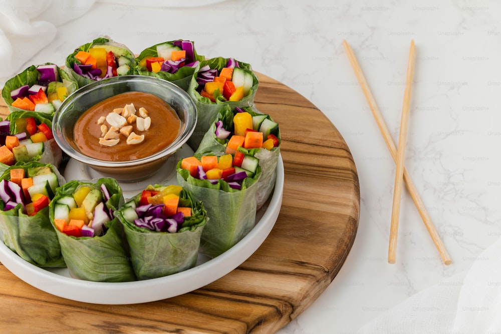 a plate of vegetable wraps with a dipping sauce