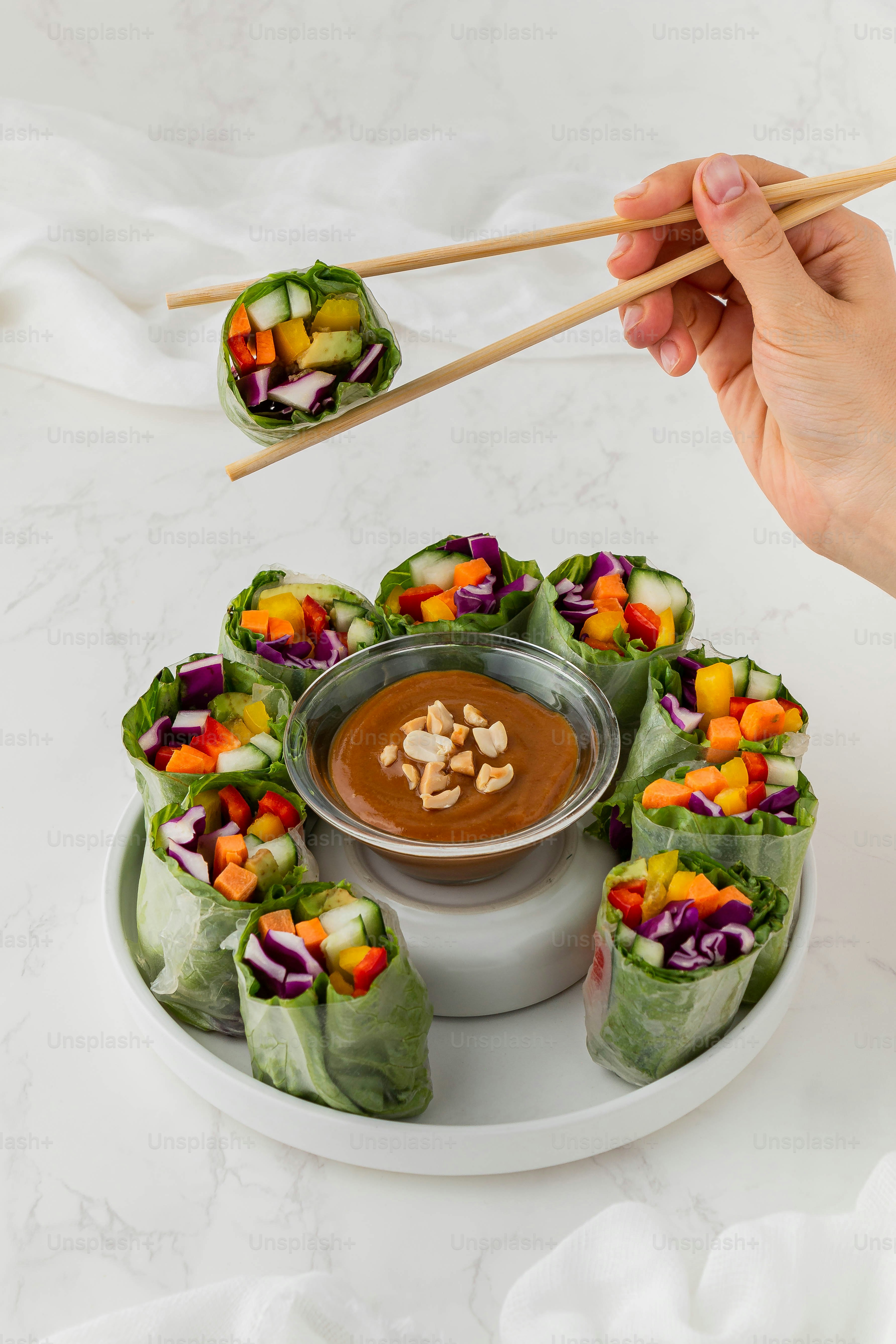 a person holding chopsticks over a plate of food