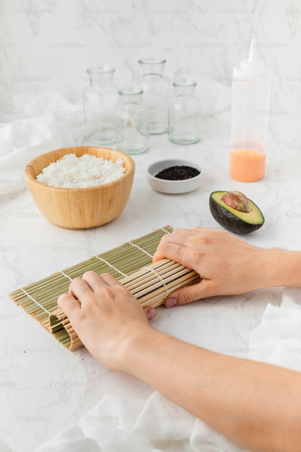 Eine Person rollt eine Bambusmatte auf einem Tisch auf