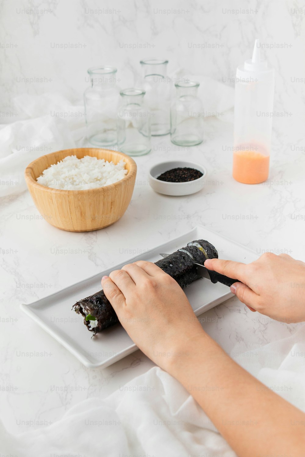 a person is holding a sushi on a plate