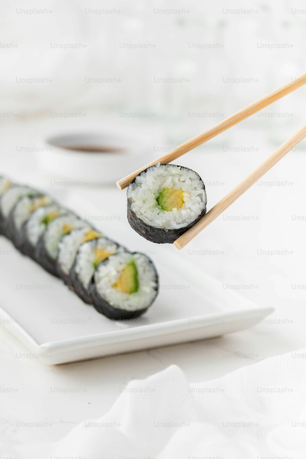 une assiette blanche garnie de sushis et de baguettes
