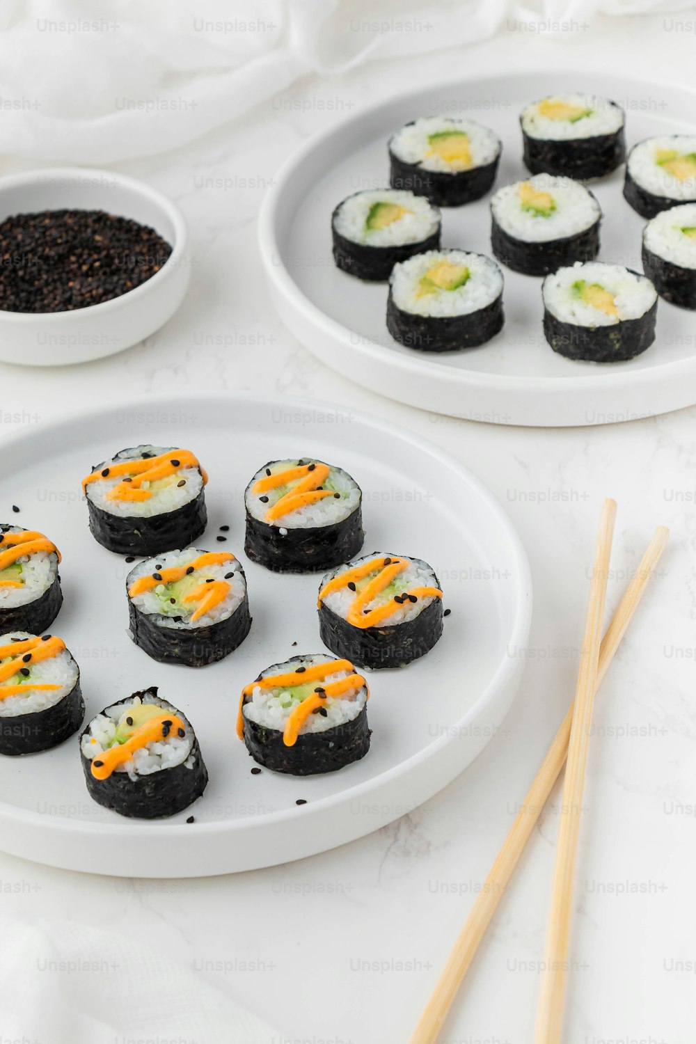 Un plato de sushi y palillos sobre una mesa