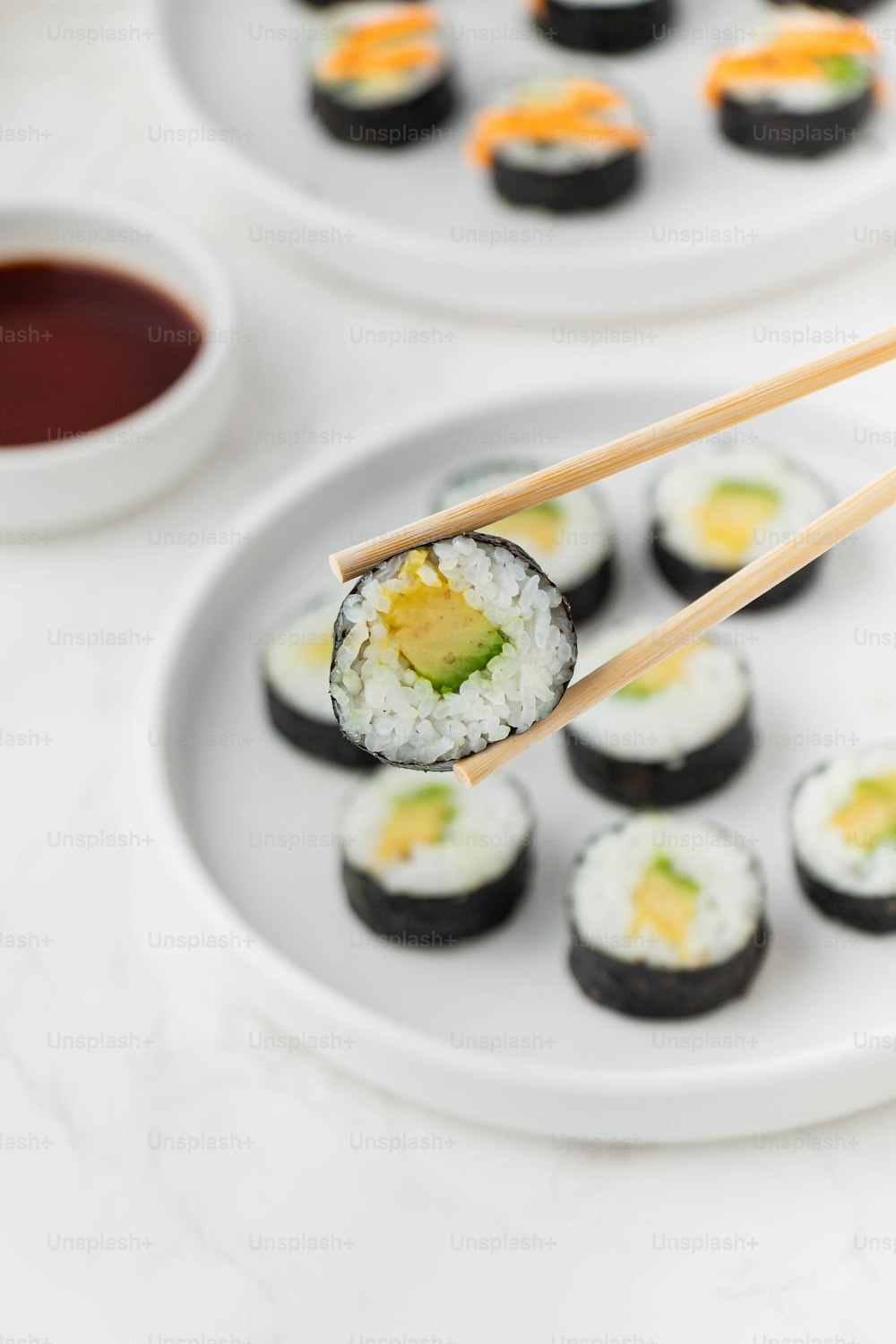 un piatto bianco condito con sushi e bacchette