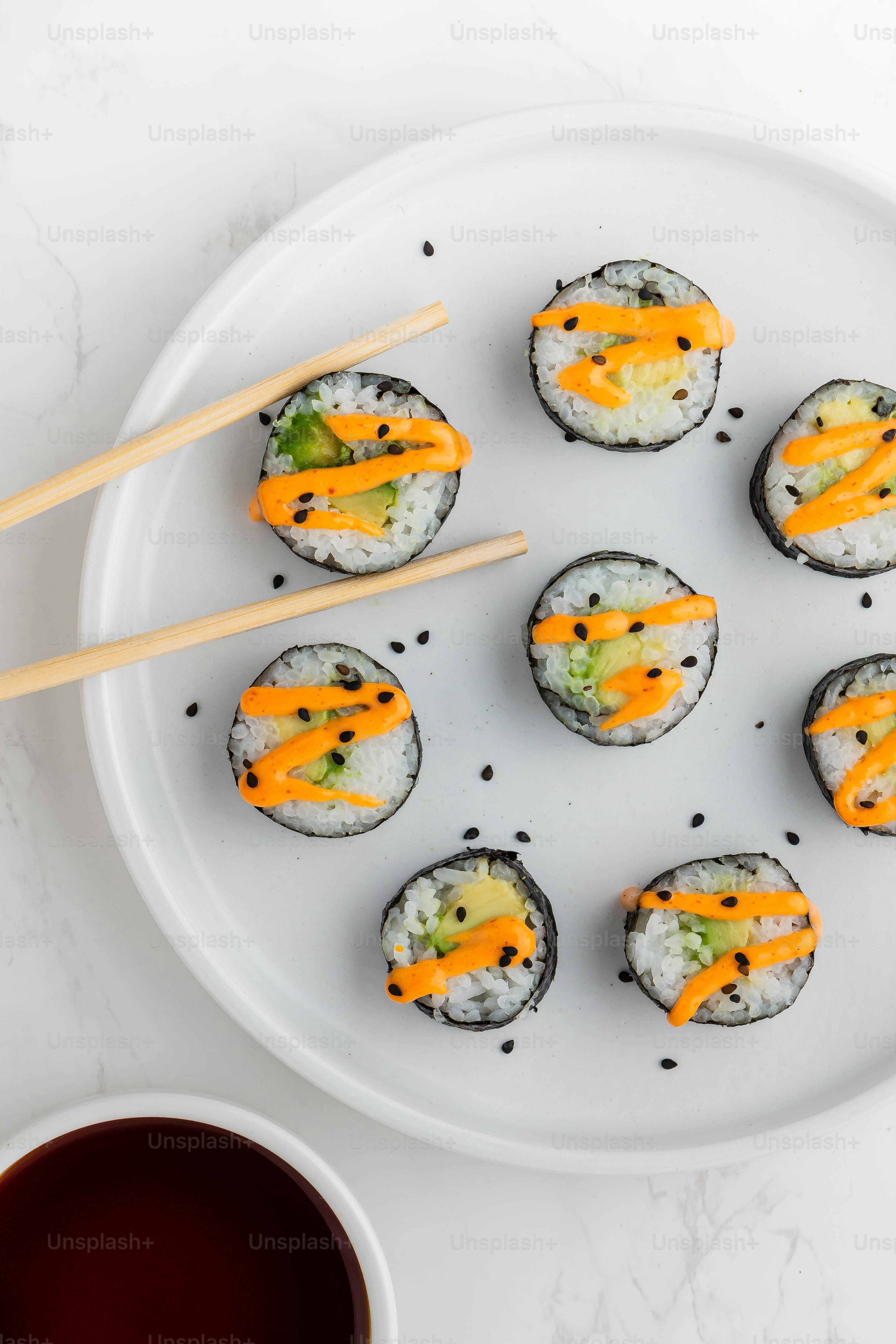 un piatto bianco condito con sushi e bacchette