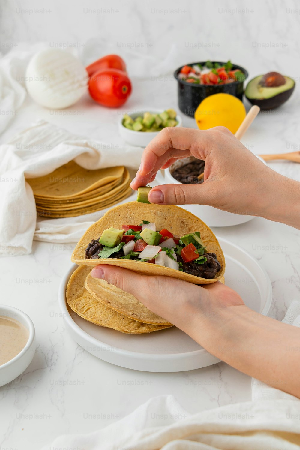a person holding a tortilla on a plate
