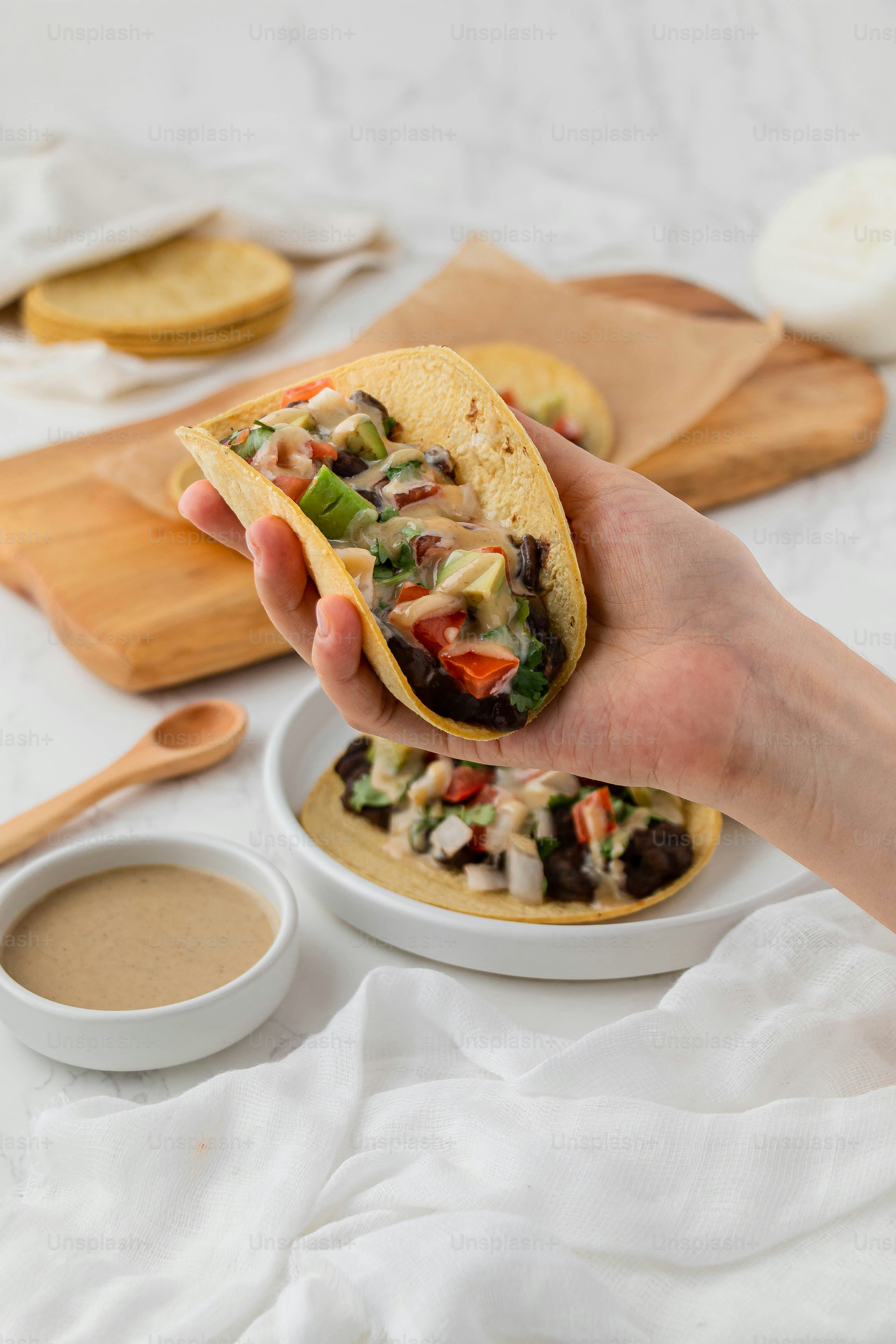 a person is holding a taco in their hand