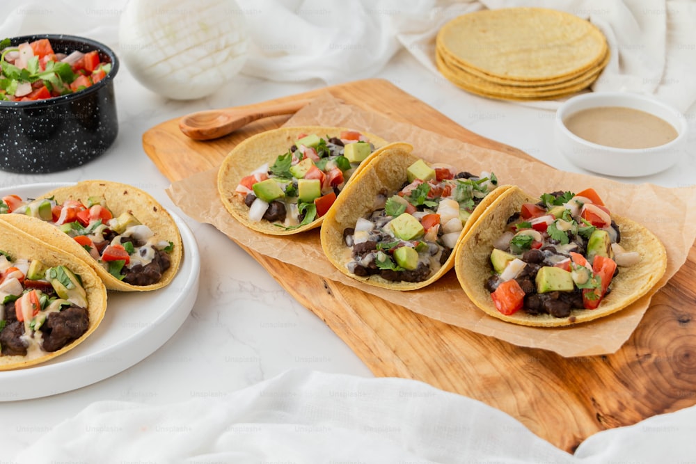 uma mesa coberta com tacos cobertos de coberturas