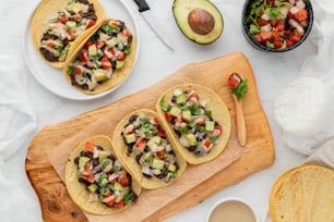 une table surmontée d’assiettes de tacos et d’un bol de salsa