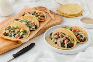 a table topped with three tacos covered in toppings