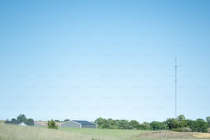 a field with a telephone pole in the distance