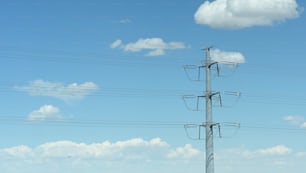 un poste telefónico con múltiples cables y un fondo de cielo