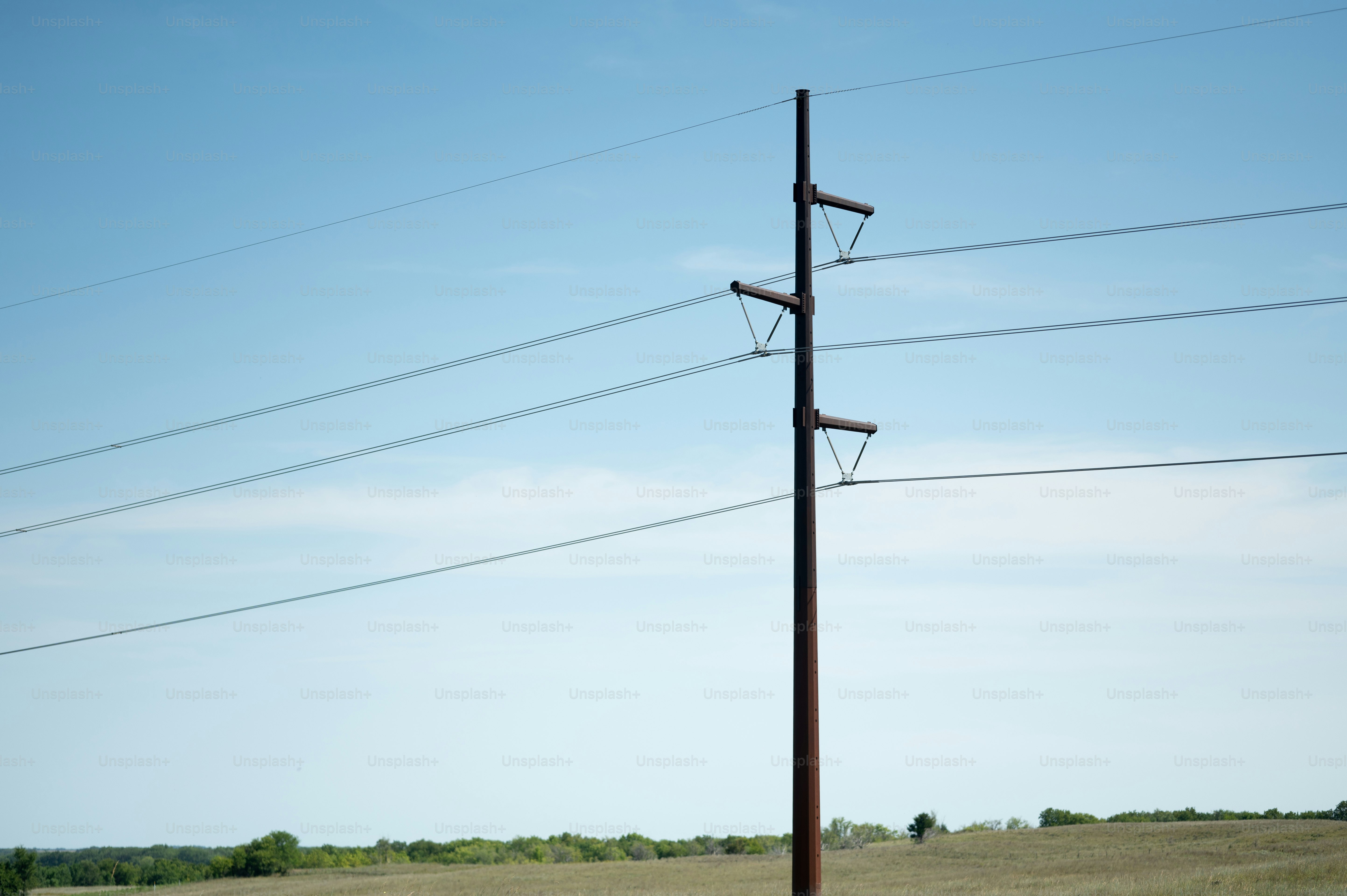 A telephone pole in the middle of a field photo Electricity Image on