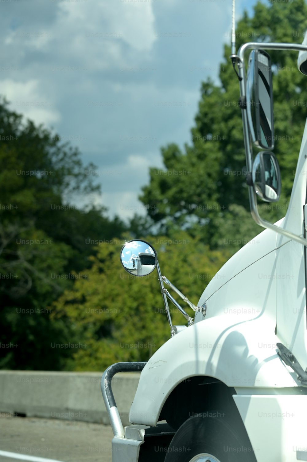 Un semi-remorque blanc roulant sur une autoroute