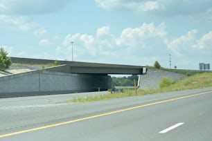 Eine Autobahn mit einer Brücke darüber an einem bewölkten Tag