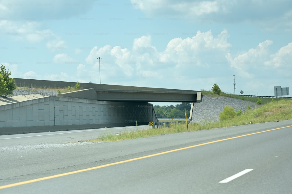 a highway with a bridge over it on a cloudy day