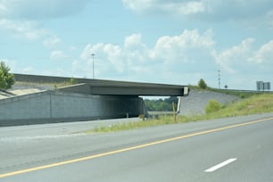 a highway with a bridge over it on a cloudy day