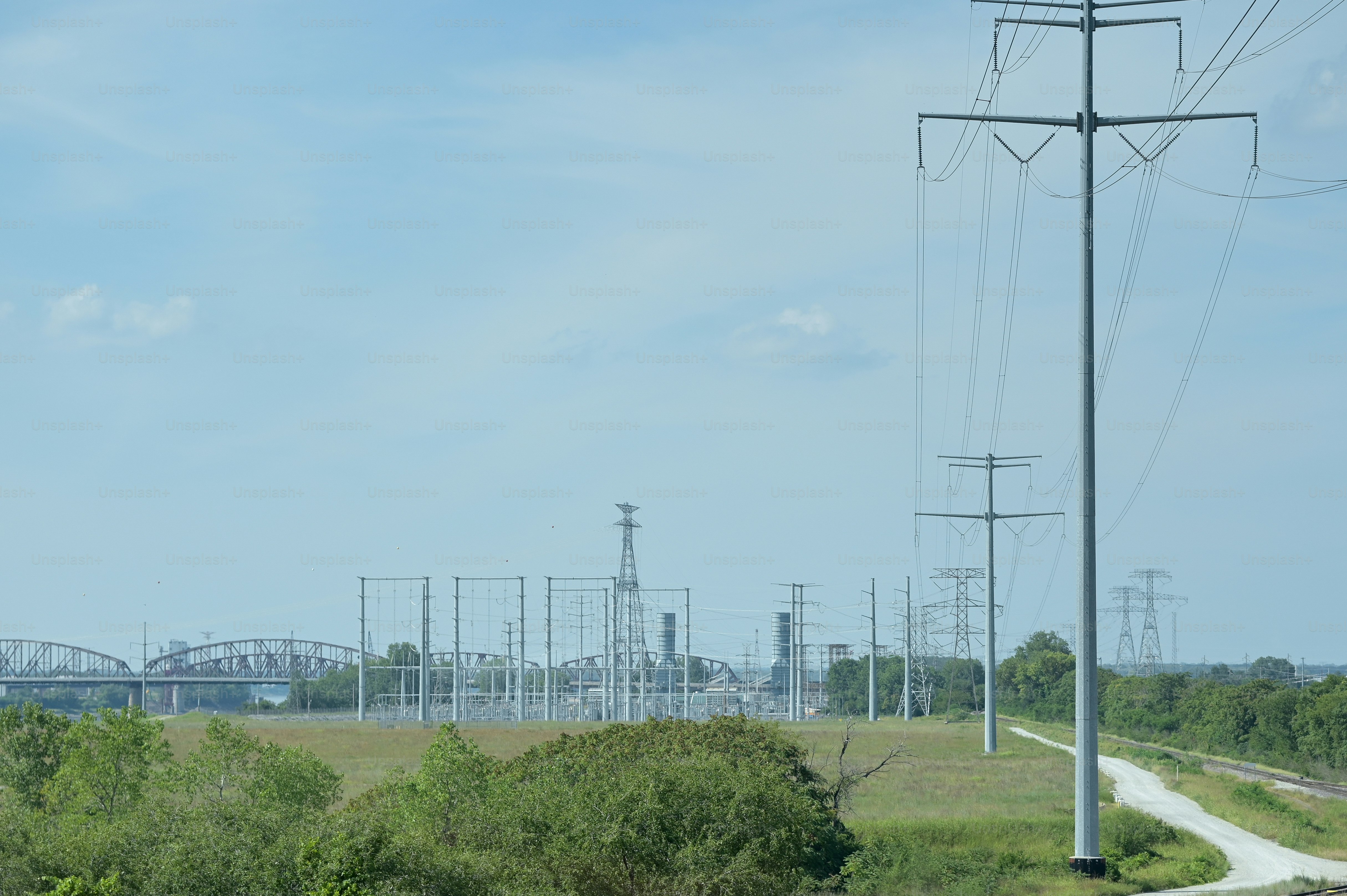 Un treno che viaggia lungo i binari accanto a un campo verde lussureggiante