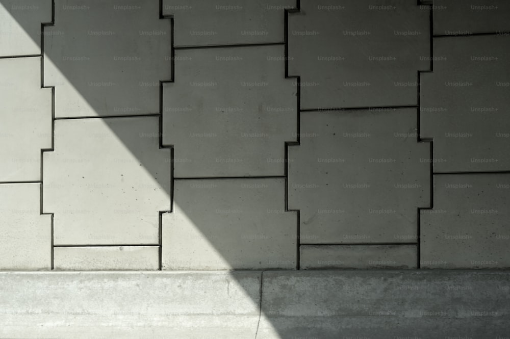 a person sitting on a bench in front of a wall