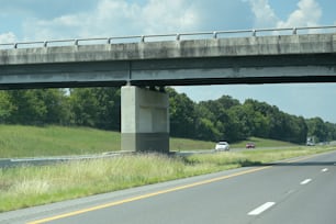 a highway with cars driving under a bridge