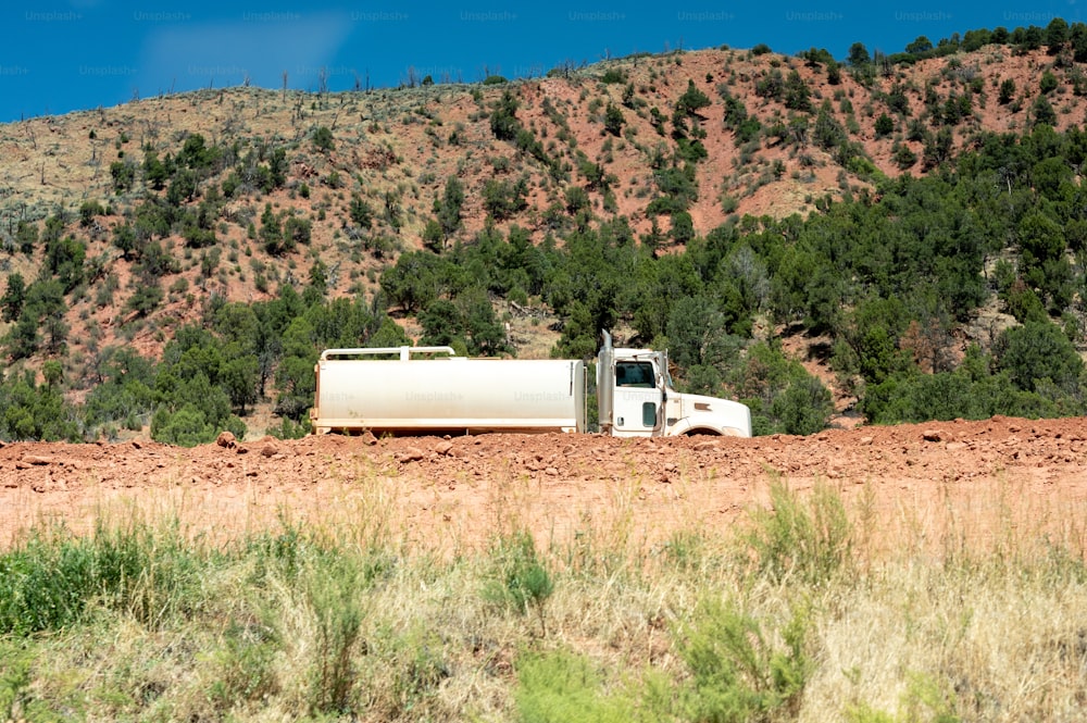 a white truck driving down a dirt road