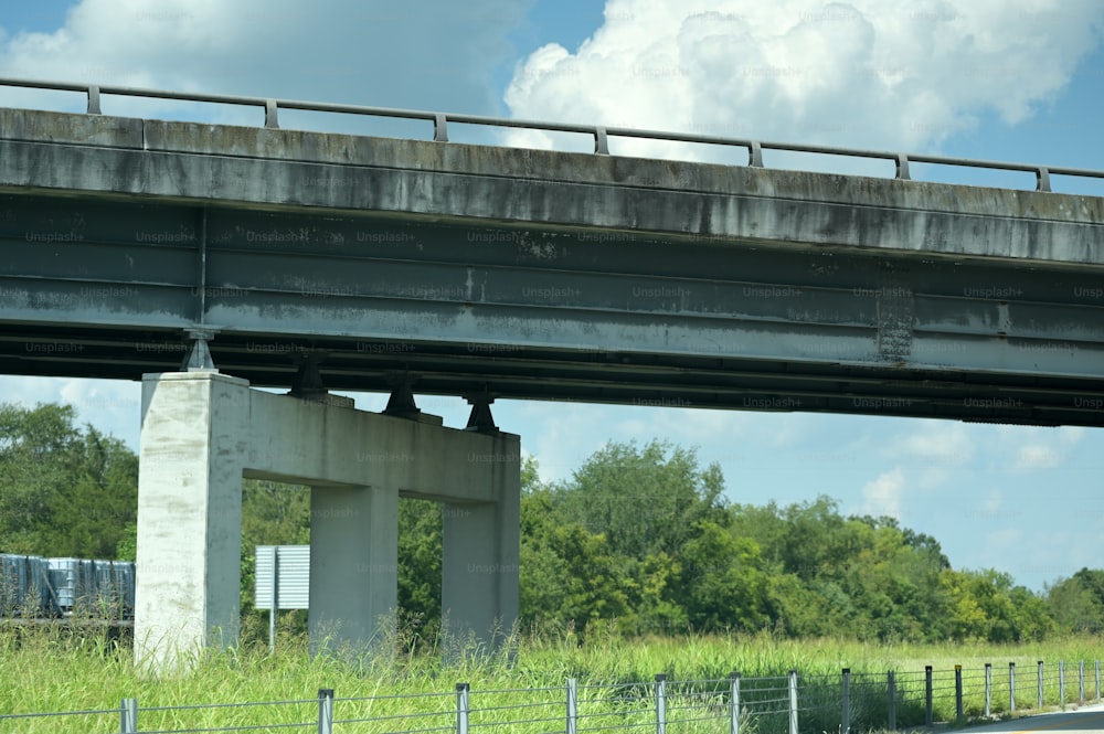 a bridge over a road with a bunch of trees in the background