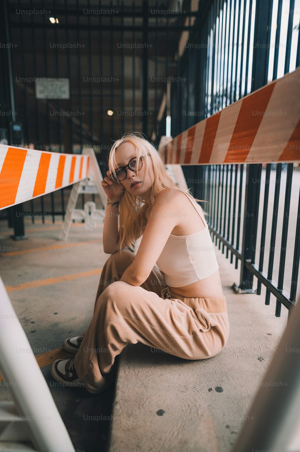 a woman sitting on the ground next to a barricade