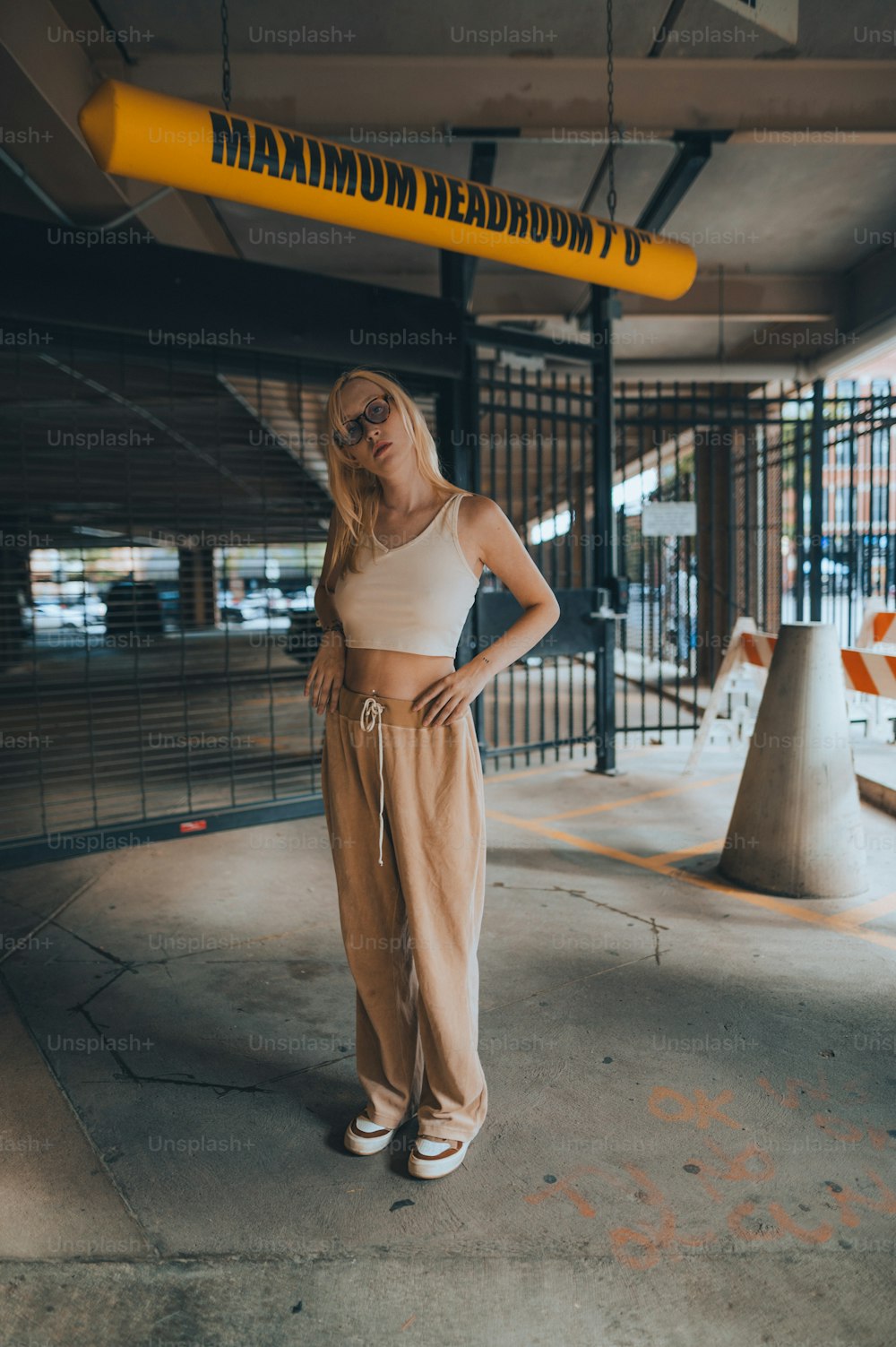 a woman standing in a parking garage with her hands on her hips