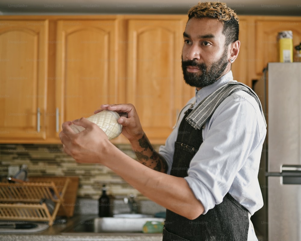 a man holding a piece of bread in a kitchen