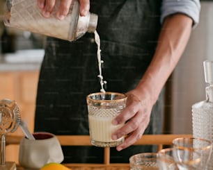 a person pouring a drink into a glass