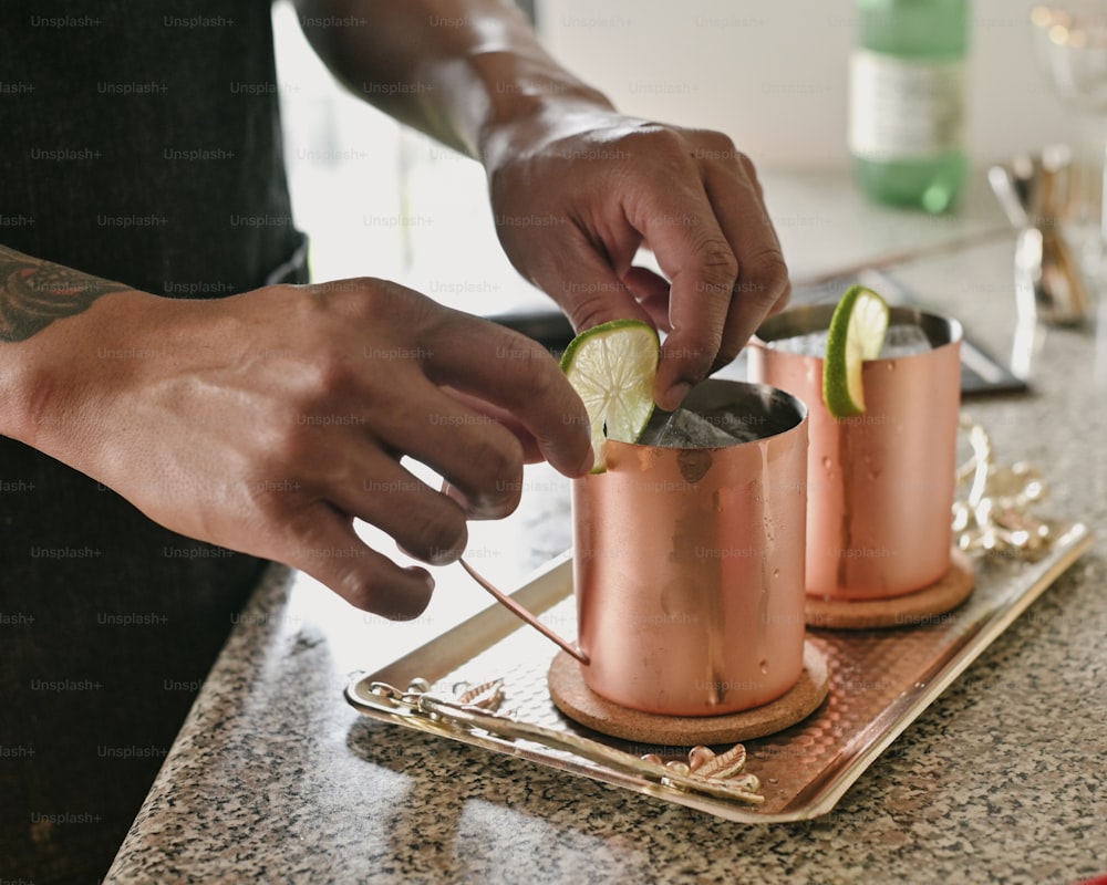 a person putting a lime in a copper cup