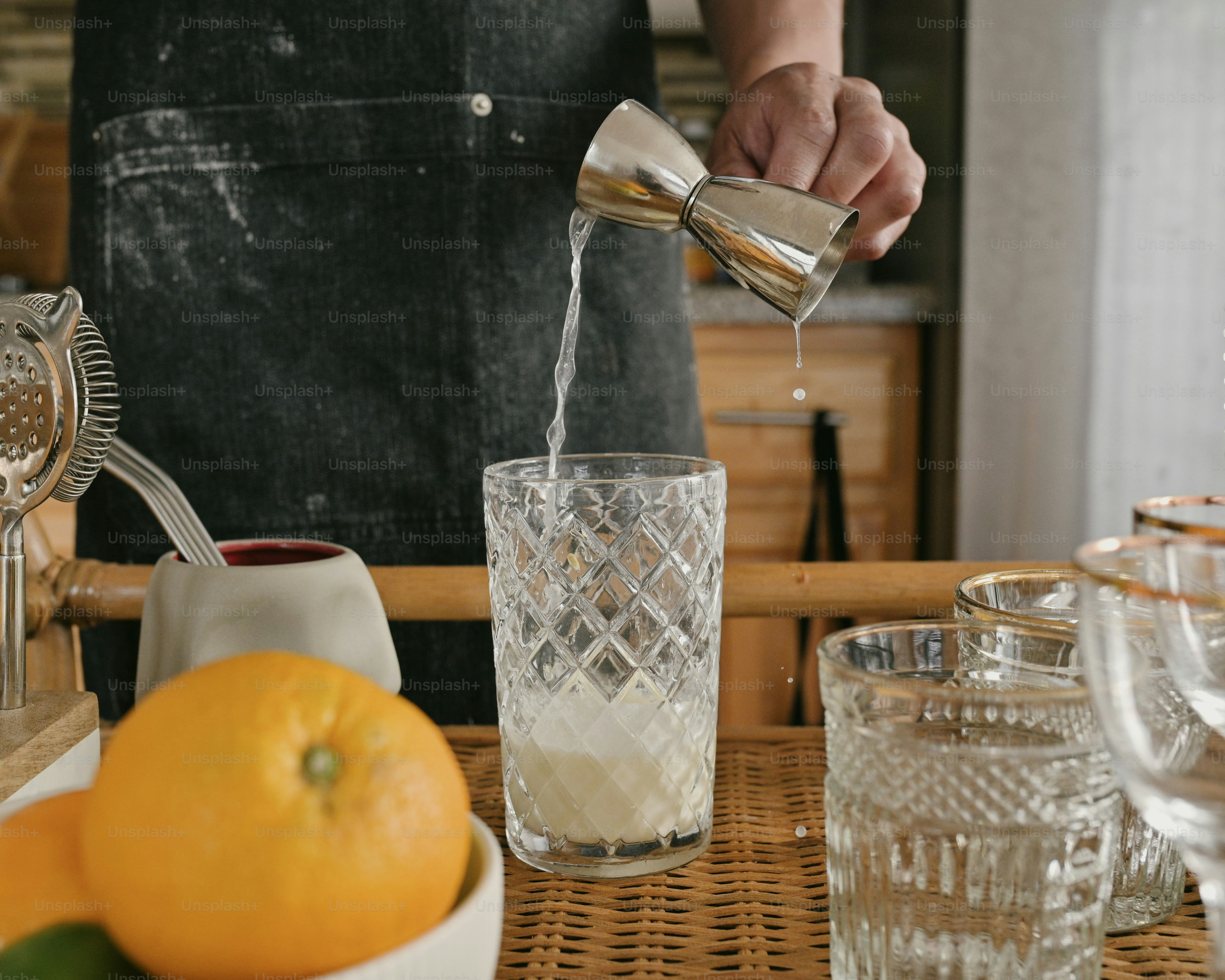 a person pouring a drink into a glass