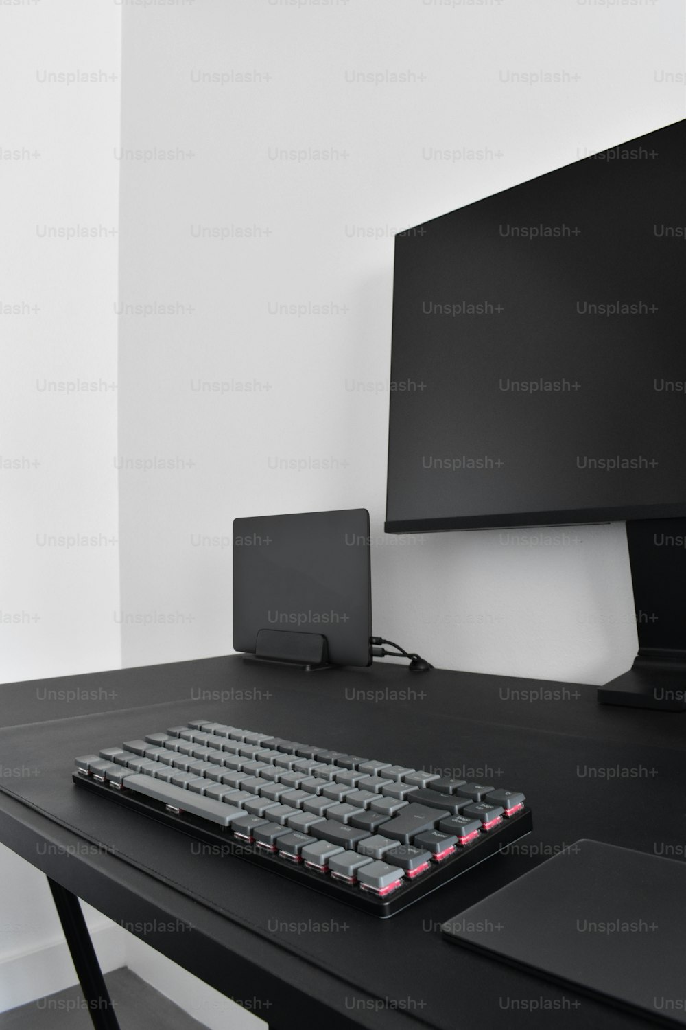 eine Computertastatur, die auf einem schwarzen Schreibtisch sitzt