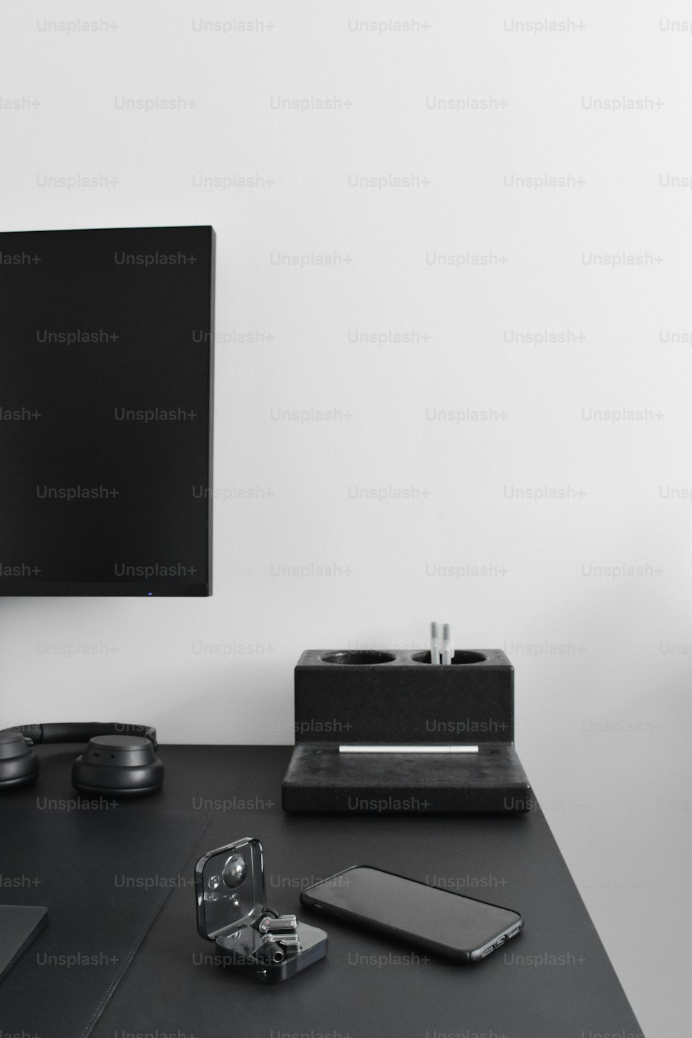 un téléviseur à écran plat posé sur un bureau noir