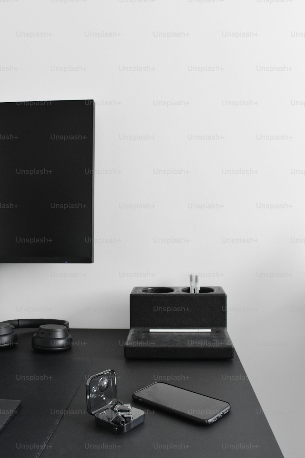 Ein Flachbildfernseher, der auf einem schwarzen Schreibtisch sitzt