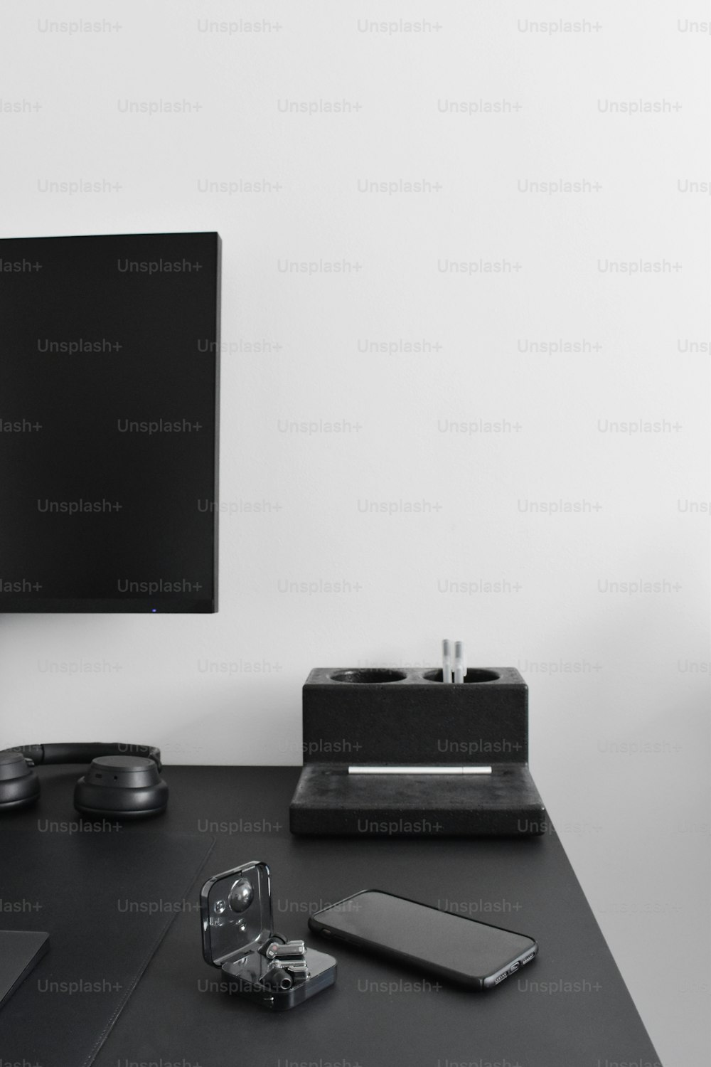 a flat screen tv sitting on top of a black desk