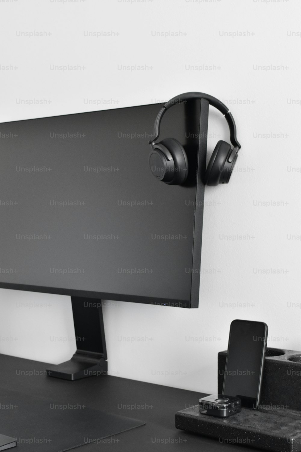 a computer monitor with headphones on a desk