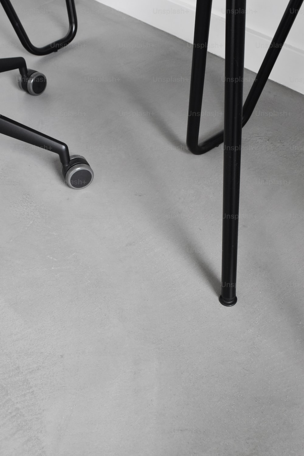 a pair of black stools sitting on top of a gray floor