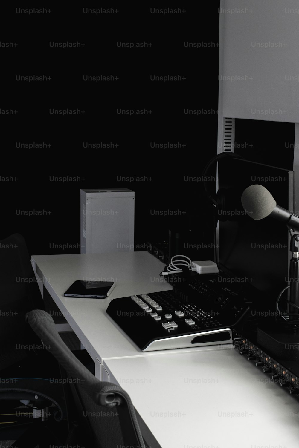 Un microfono è seduto su una scrivania accanto a un computer