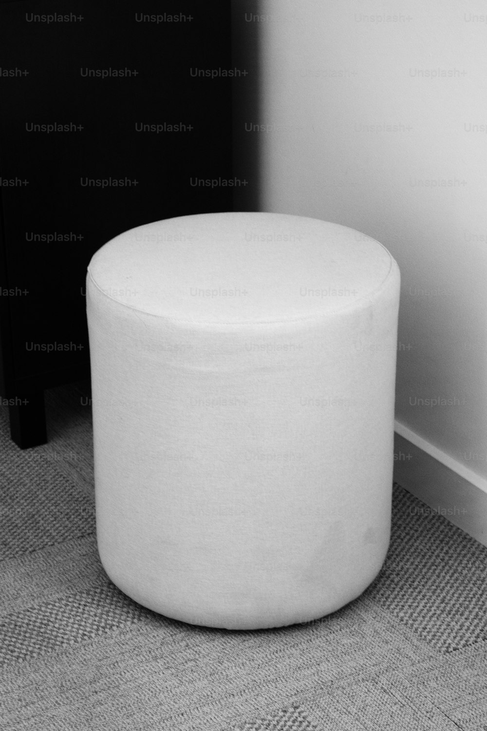 카펫 바닥 위에 앉아 있는 하얀 의자
