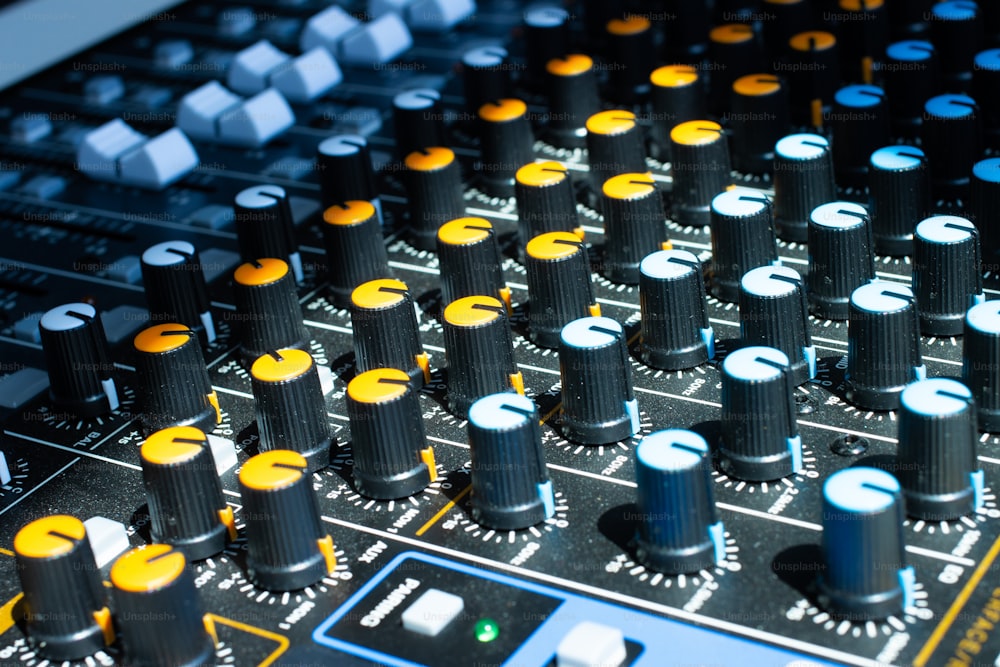 a close up of a sound board with many knobs