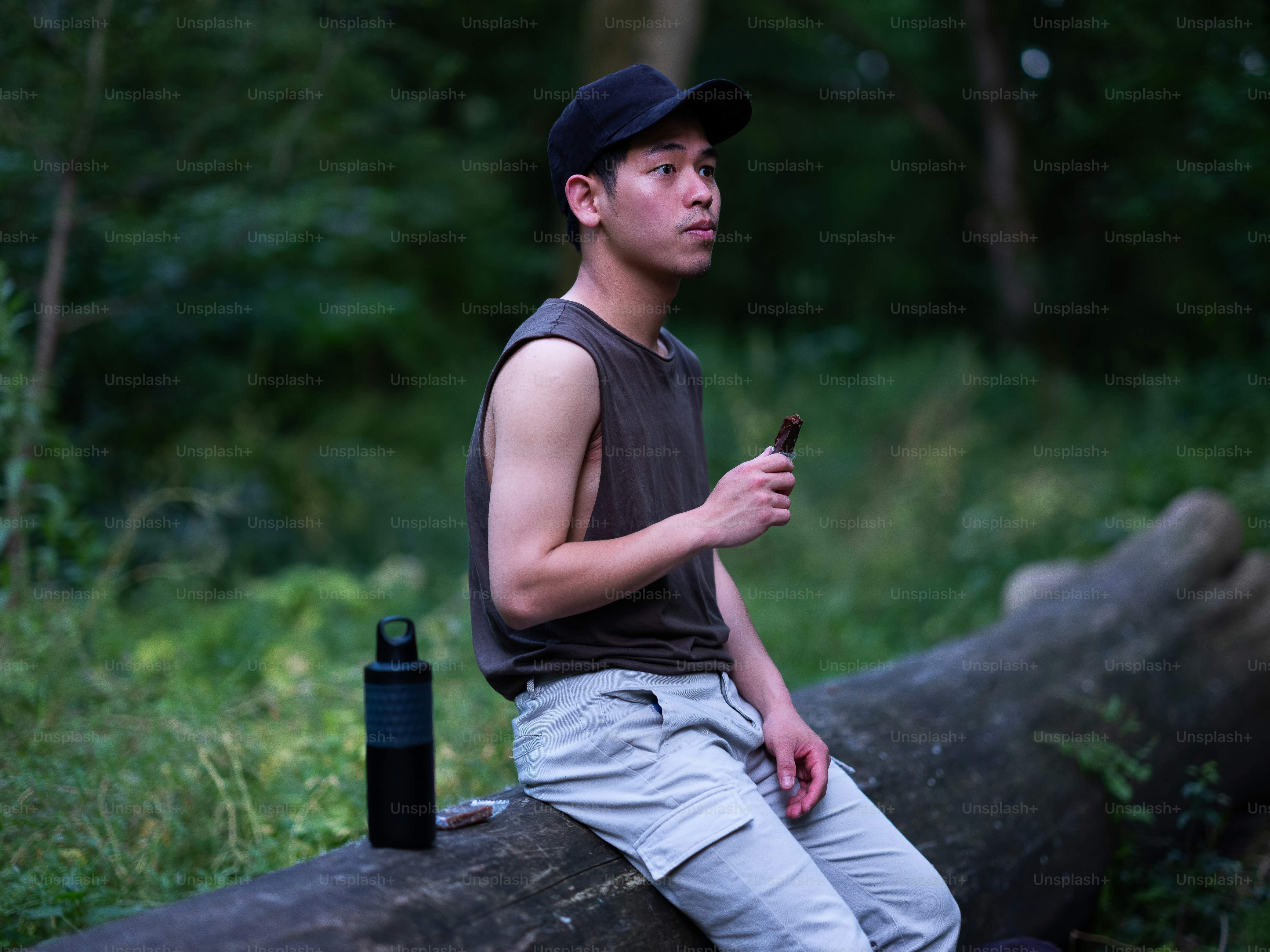 um homem sentado em um tronco na floresta
