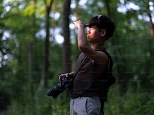 카메라를 들고 숲에서 사진을 찍는 남자