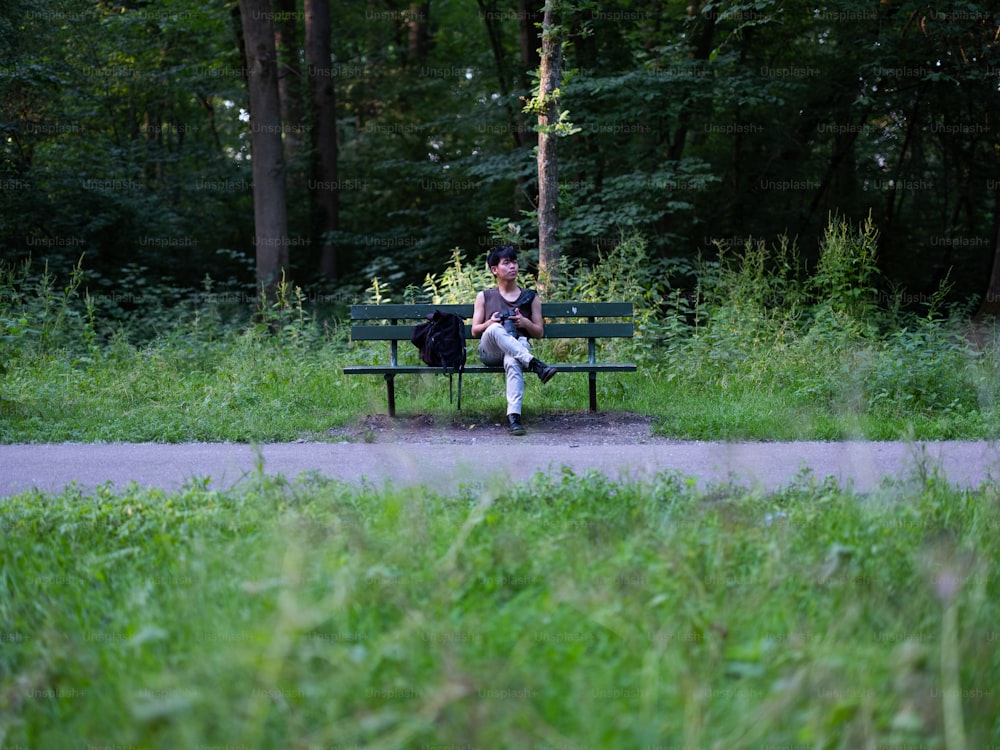 a person sitting on a bench in a park
