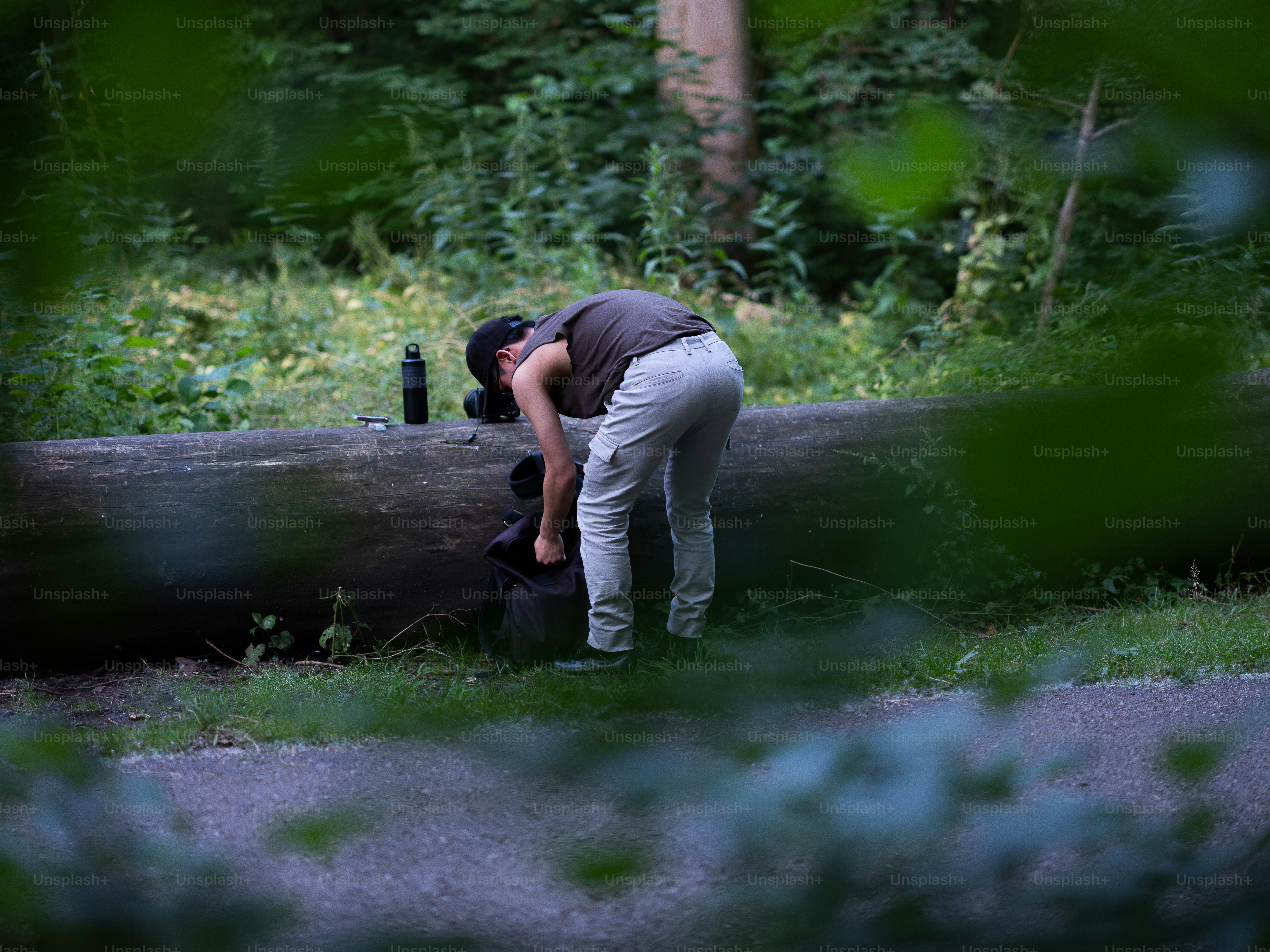 Una persona inclinada sobre un tronco en la hierba foto – Imagen de ...