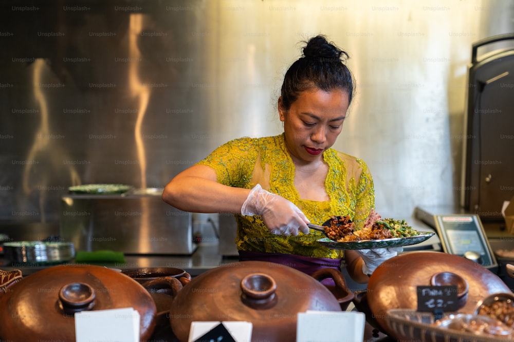 Una mujer en una cocina preparando comida en un plato