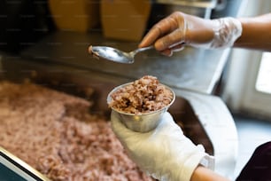 a person holding a spoon over a bowl of food