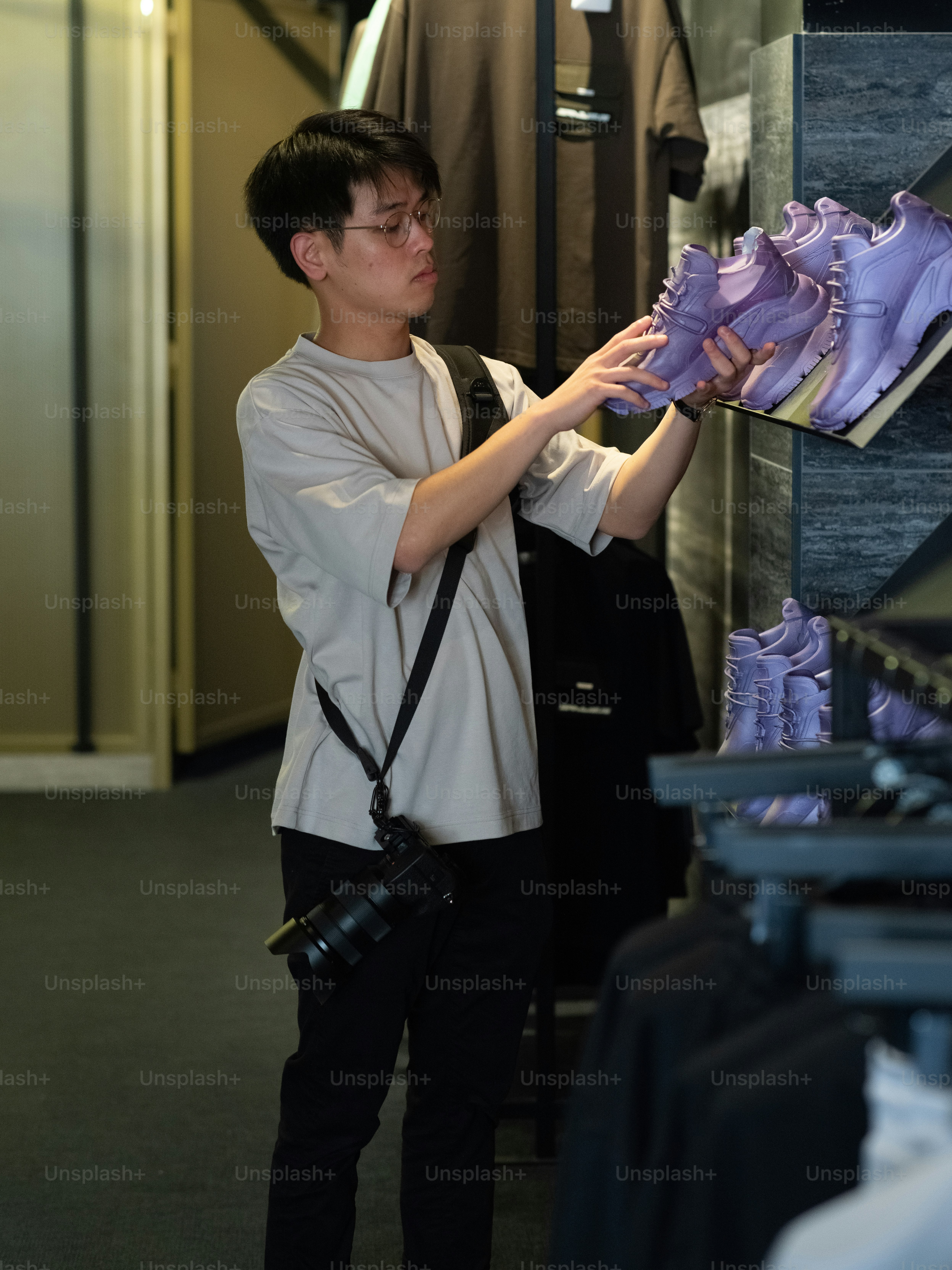 a man looking at a pair of purple shoes